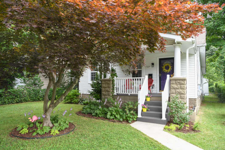 Exterior of a white house with steps leading up to a porch