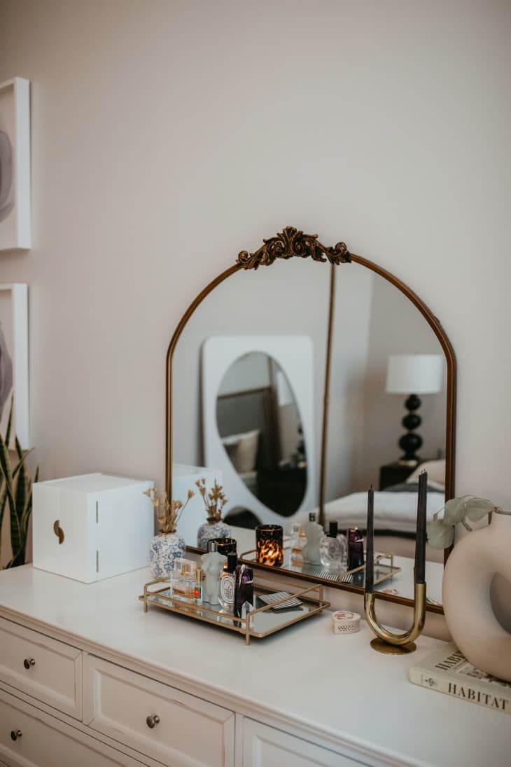 White dresser with a mirror and trinkets on top