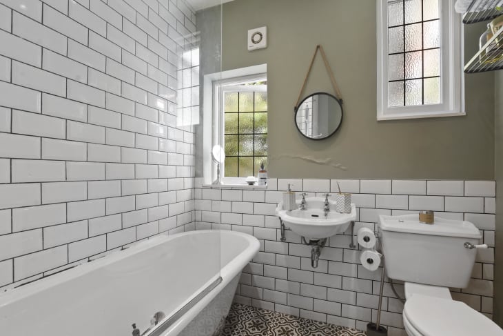 Bathroom with white tiles and a large tub