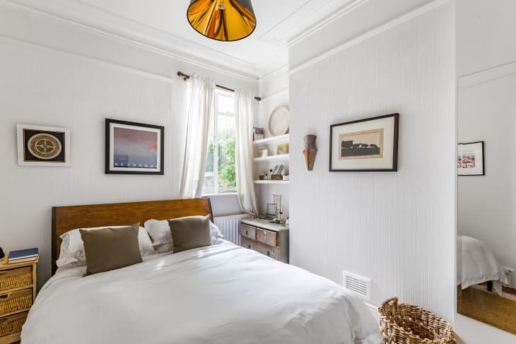 White bedroom with a white bed and art on the walls