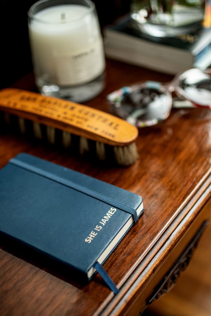 A blue notebook next to a brush on a desk