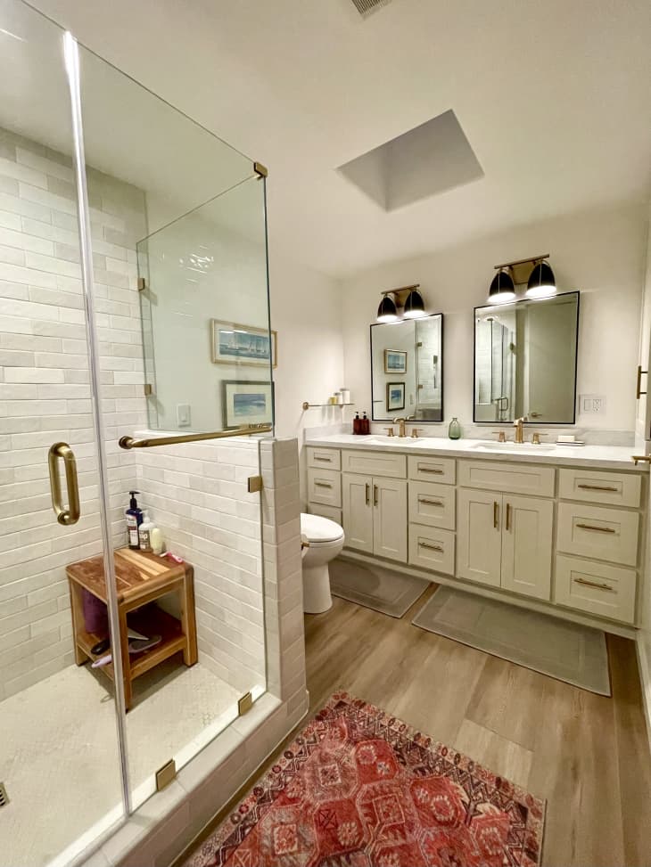 A bathroom with glass door shower and a double sink