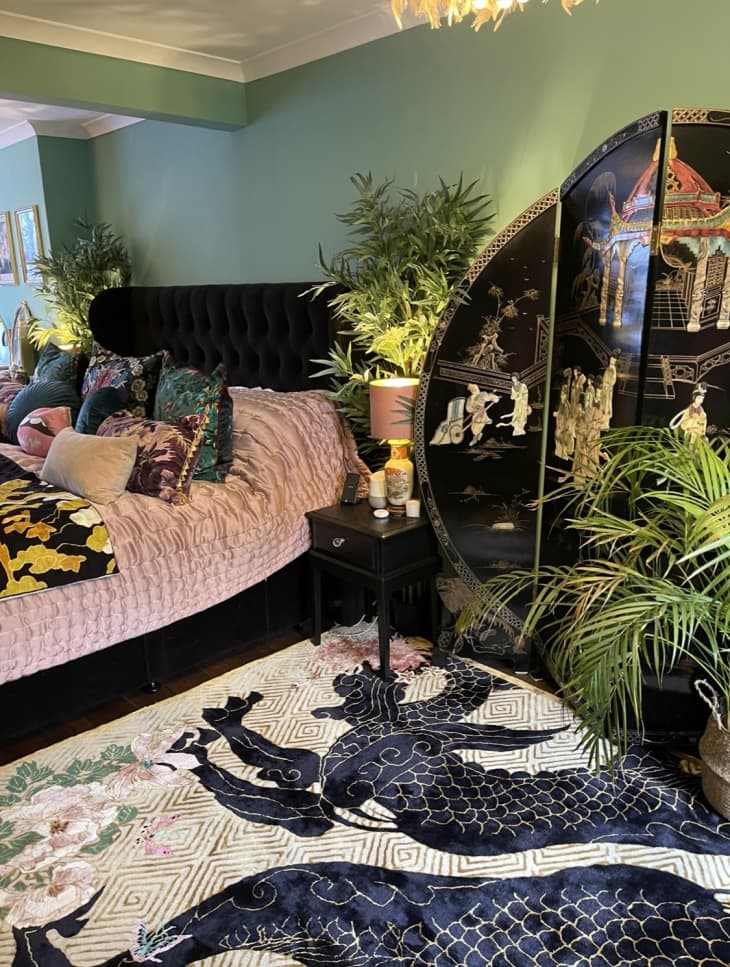 绿色的卧室，有大植物和粉红色的床