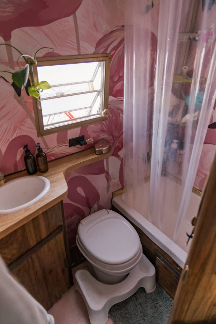 小露营风扇房车浴室与粉红色火烈鸟墙纸和木质镶板橱柜