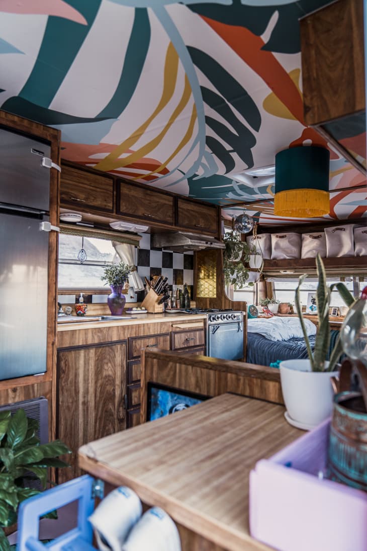 内部整体上世纪70年代的露营车装修，木质镶板橱柜和花卉墙纸天花板