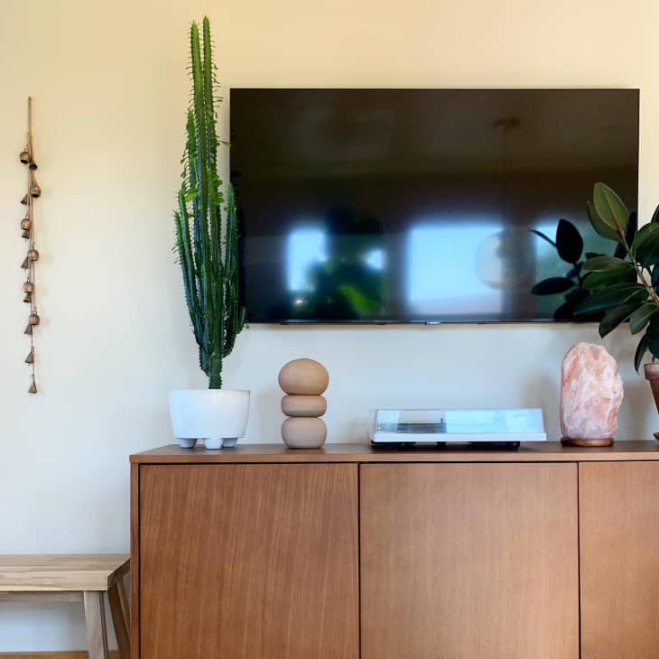 A tv mounted on a wall above a tv stand
