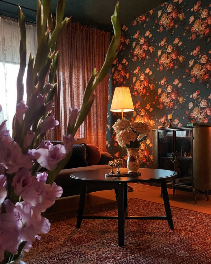 Flowers in a living room with floral wallpaper