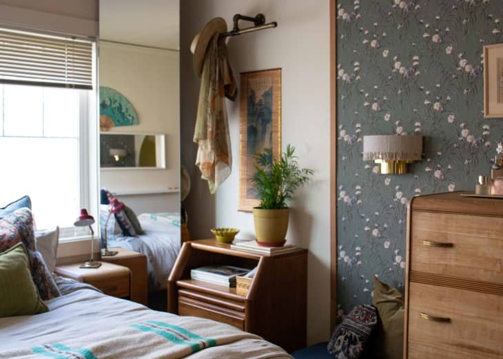 Vintage fabric used as wallpaper decorates a bedroom