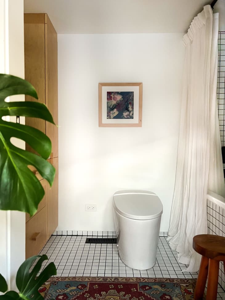 A bathroom with plants and white tiled floors