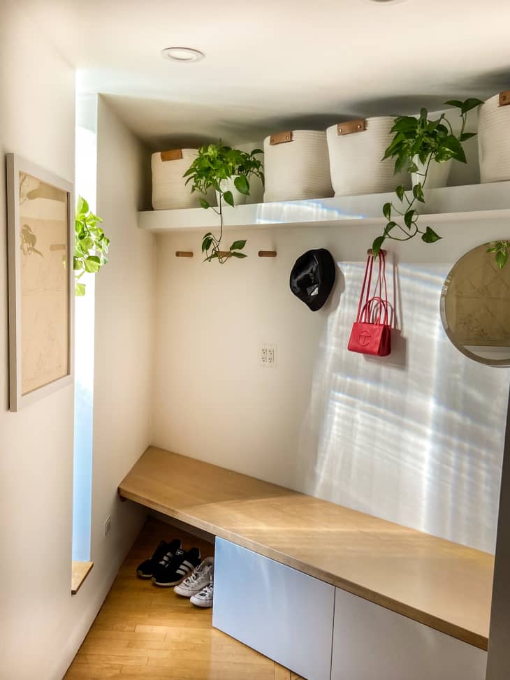 An entryway with a bench a space to hang hats and bags