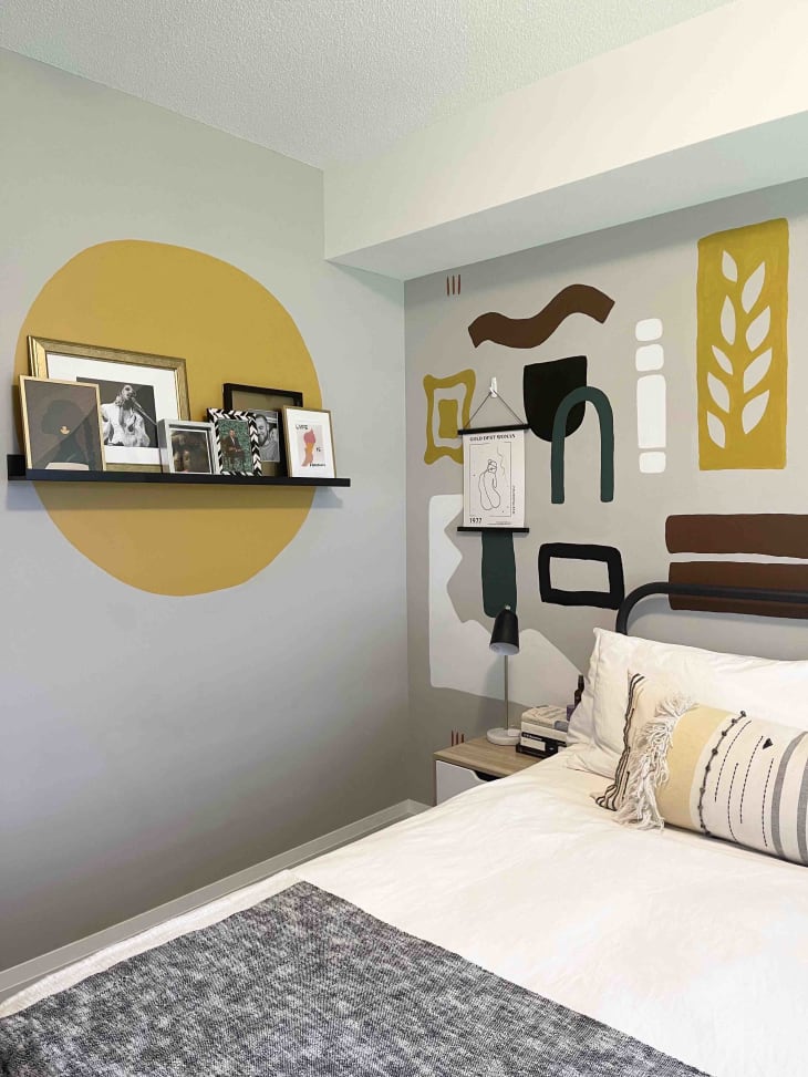 A bedroom with yellow art painted onto the walls