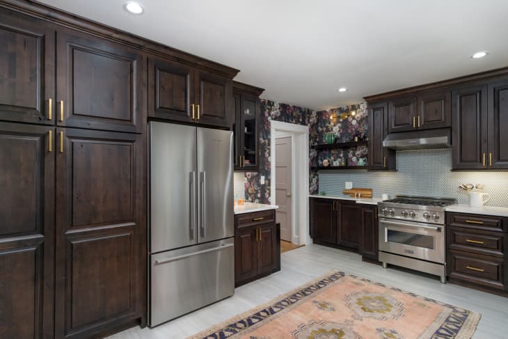 A kitchen with dark wooden cabinets and stainless steel appliances
