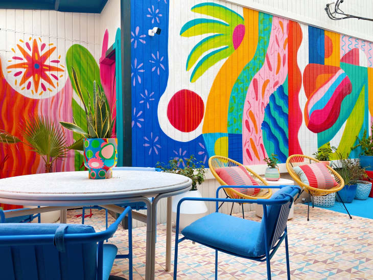 A colorful mural with colorful chairs and tables
