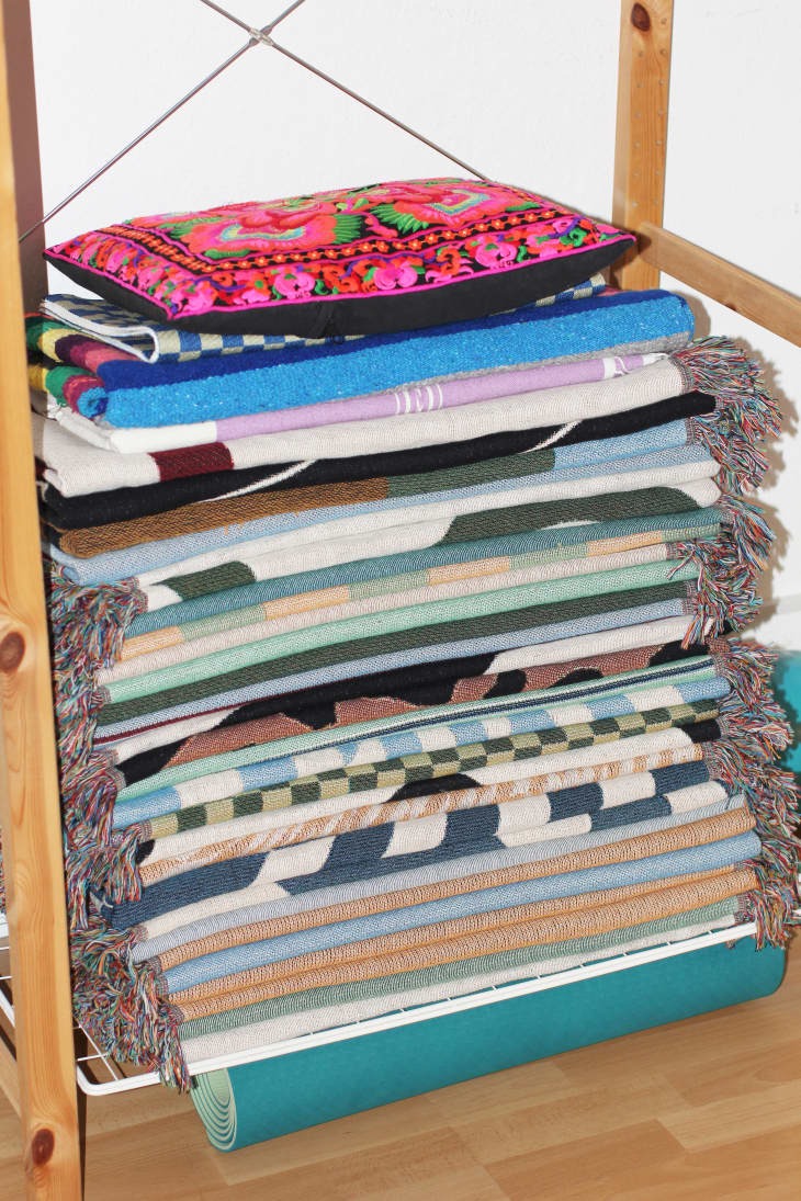 A shelf with a stack of blankets