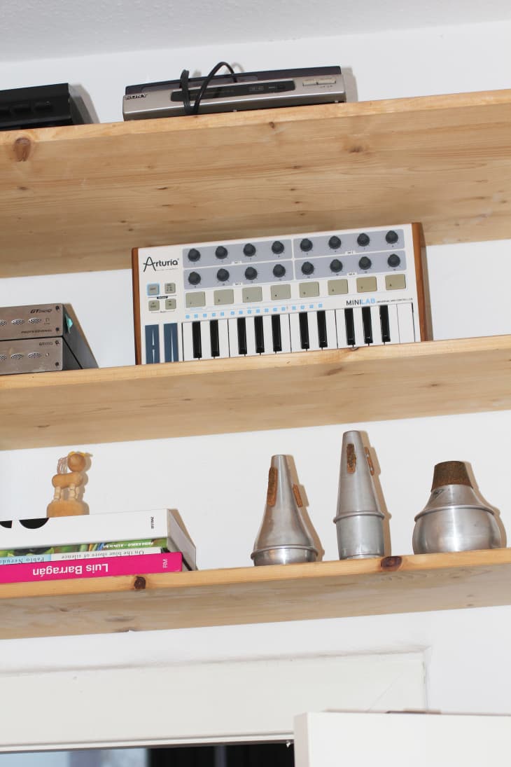 Three wooden shelves against a white wall