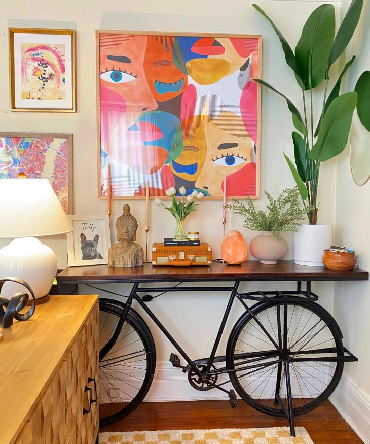 Vintage bike turned table with lots of plants and a small alter space on top of wood plank.