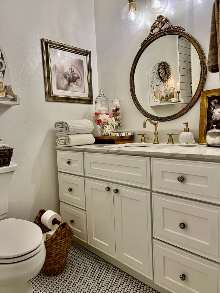 White bathroom with vintage mirror and penny tile.