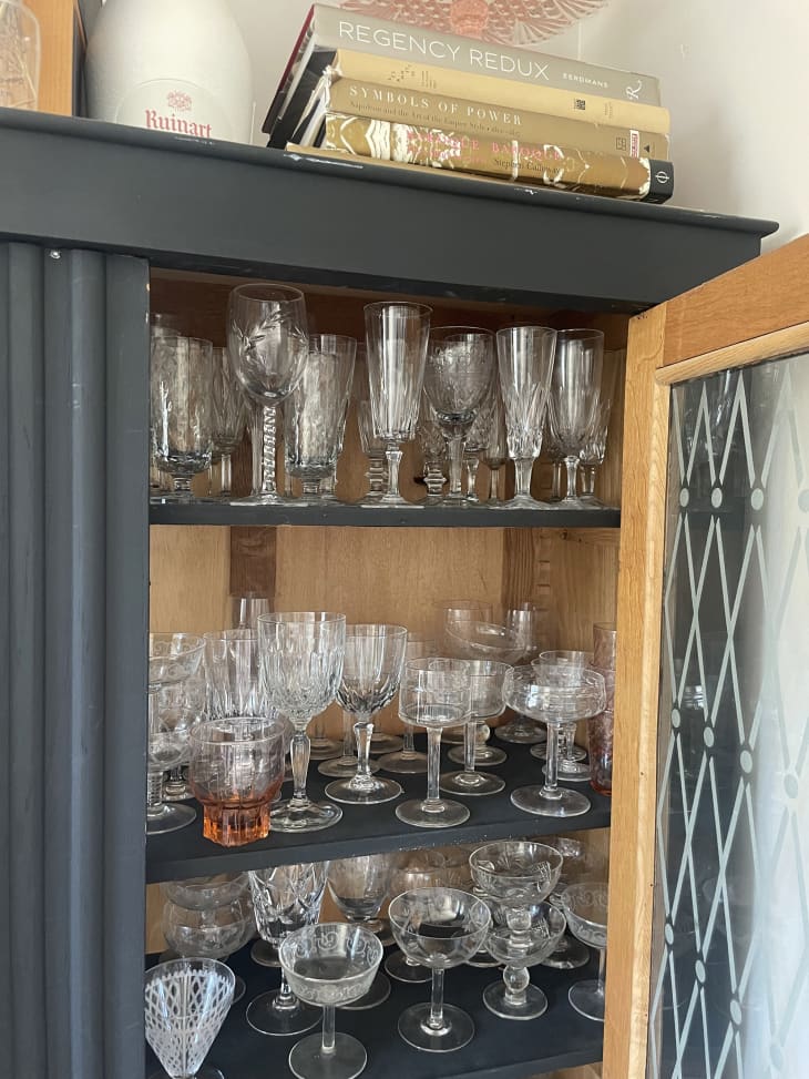 Black or dark blue/gray hutch with various drinking glasses inside