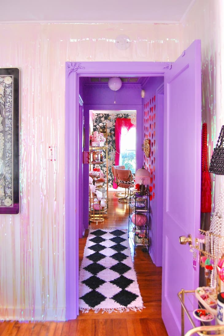 View into lavender hallway with red hearts on wall, black and white harlequin shag rug