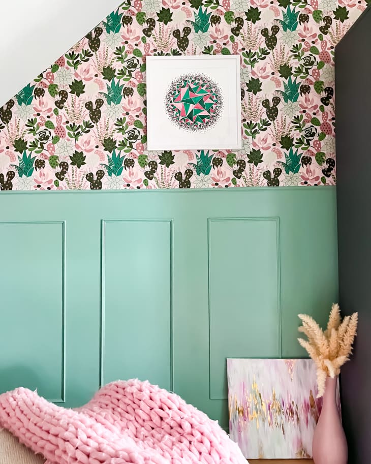 bedroom with pink. mint, white walls with pink and green botanical wallpaper, bed with pink, white and green bedding, angled ceiling
