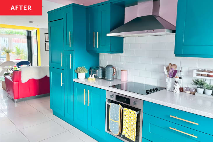 Kitchen after renovation/painting. Bright turquoise cabinets and drawers, pink ceiling, white counters, white subway tile backsplash, bright brass/gold hardware, yellow and pink accents