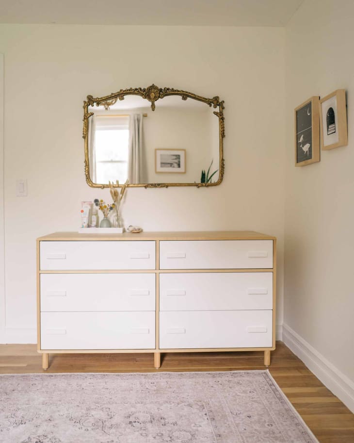 White dresser with vintage mirror above in newly renovated home.