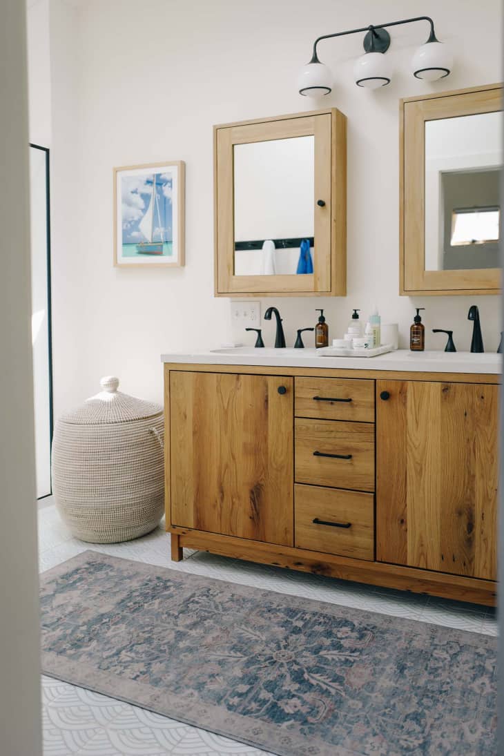 Light colored bathroom with light wood vanity after renovation.