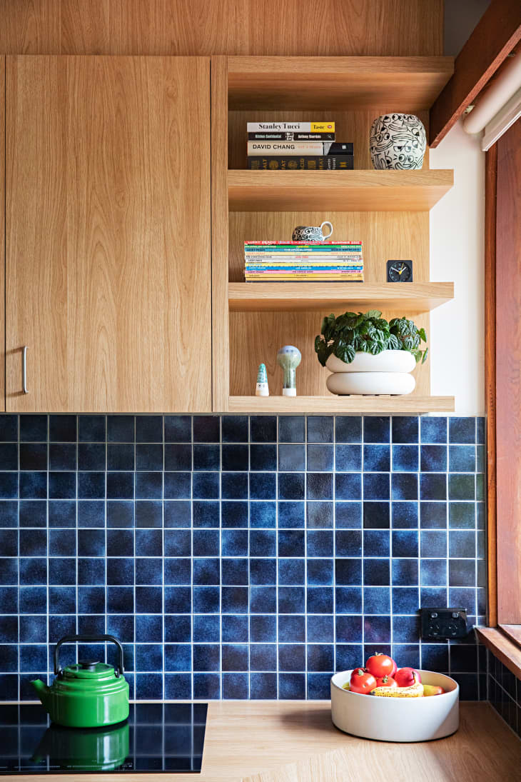 view of kitchen blue tile backsplash, wood cabinets/shelves