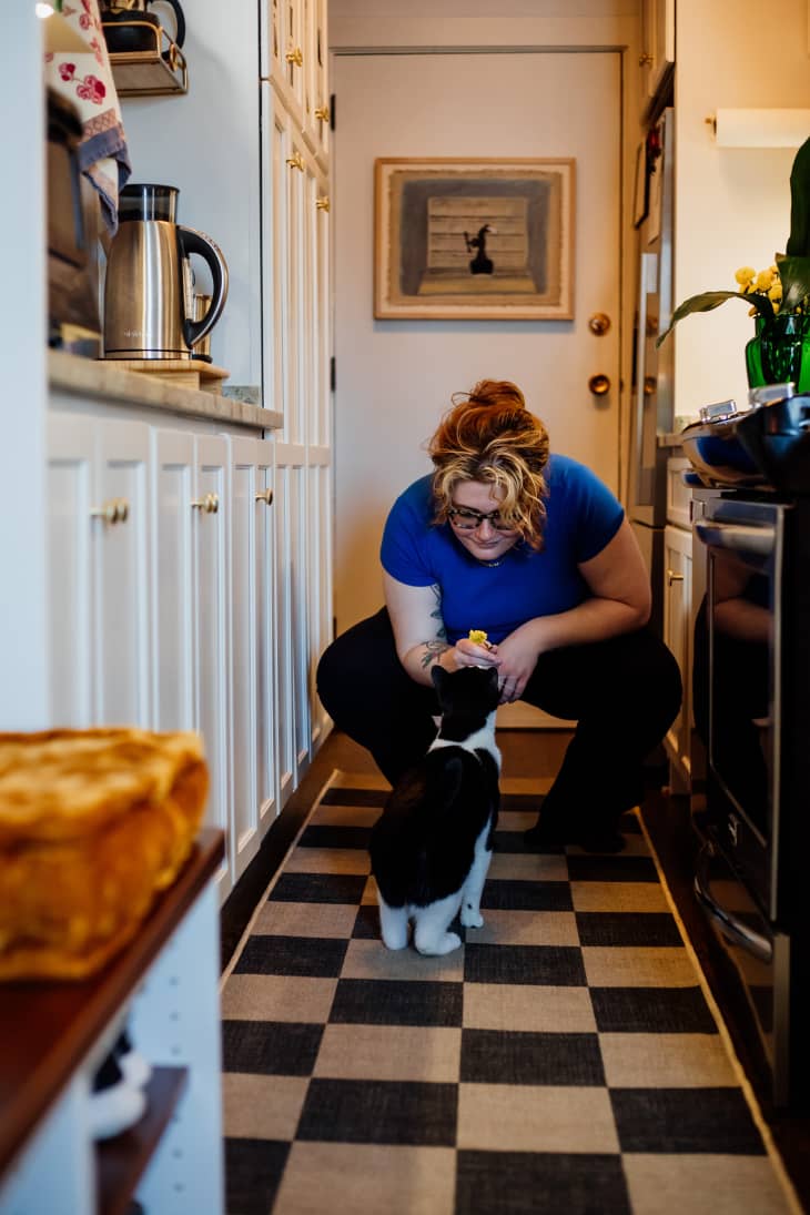 woman in the kitchen with her black and white cat in her Chicago apartment