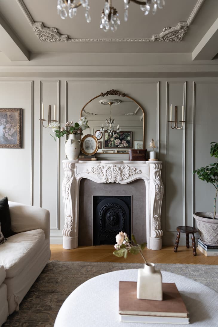 Ornate white fireplace with mirror in neutral colored living room