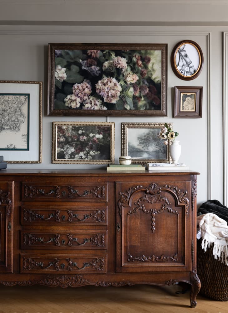 Ornate dark wood sideboard with art in neutral living room