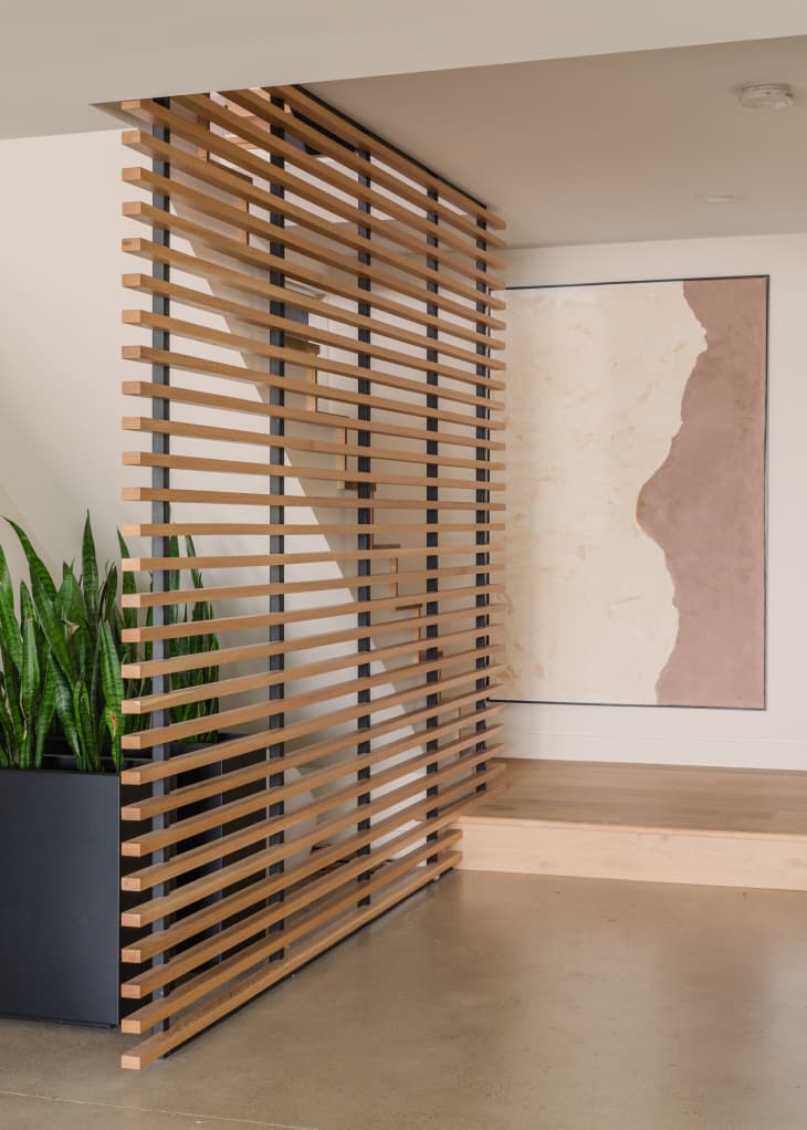 hallway or entry area with modern wood slatted screen/divider
