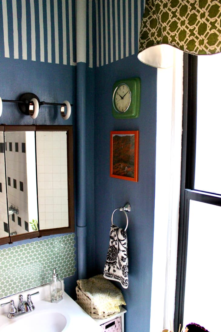 Blue and white stripes painted on upper wall in blue bathroom.