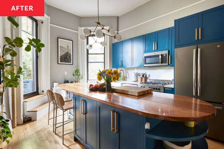 gray kitchen after renovation with Blue cabinets and wood finish countertop on oval island