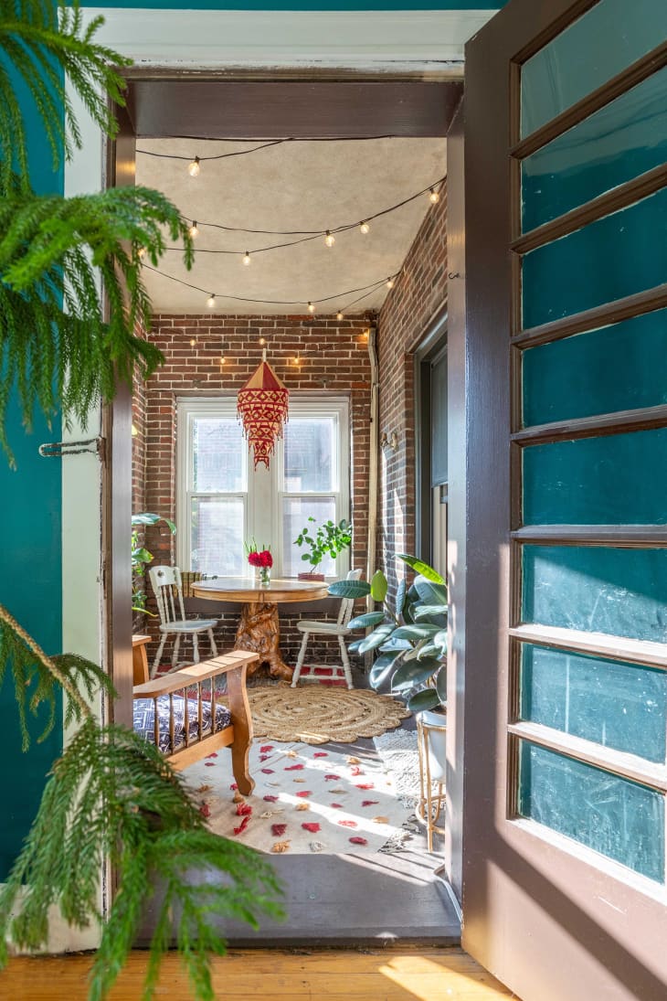 View from sunroom into exposed brick dining nook
