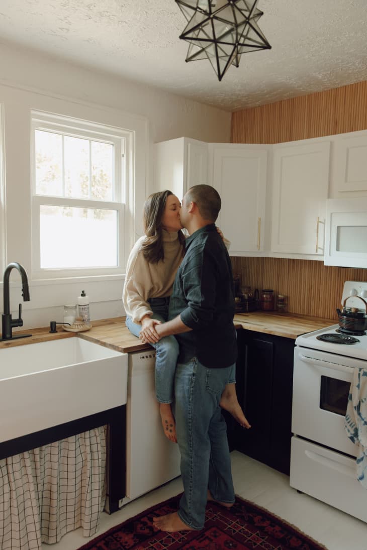 A couple kissing in their kitchen
