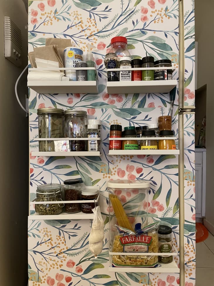 Floral wallpaper behind a spice rack