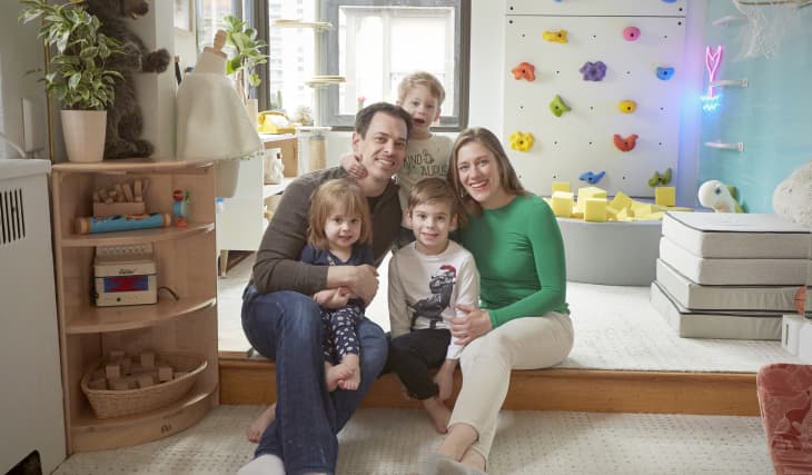 Family smiling in playroom.