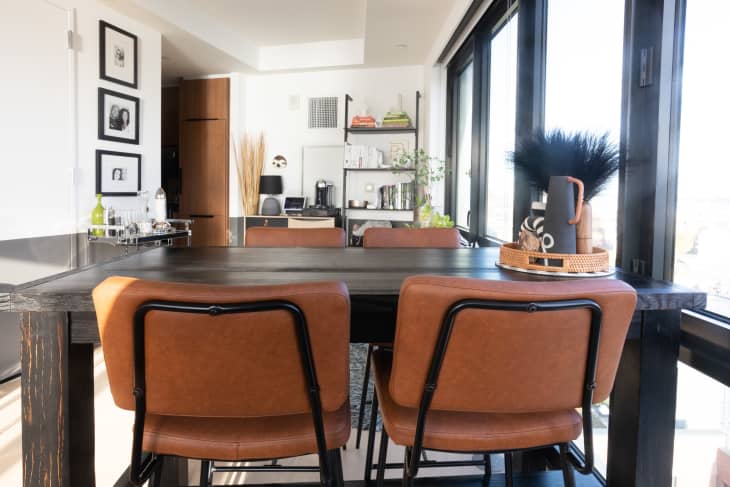 Dining room with dark wood table, terracotta leather chairs, large windows