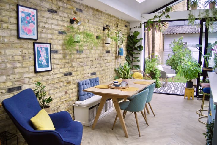Dining table in plant filled kitchen.