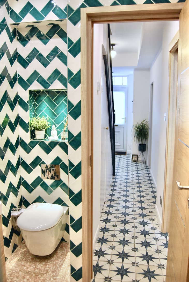 Blue and white chevron tiles in bathroom. Looking through doorway into blue star motif hallway tile.