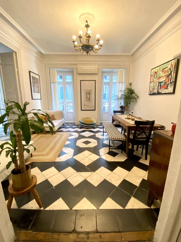An entryway with black and white tiled floors and a chandelier