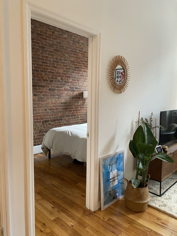 The entrance to a bedroom with exposed brick from the living room