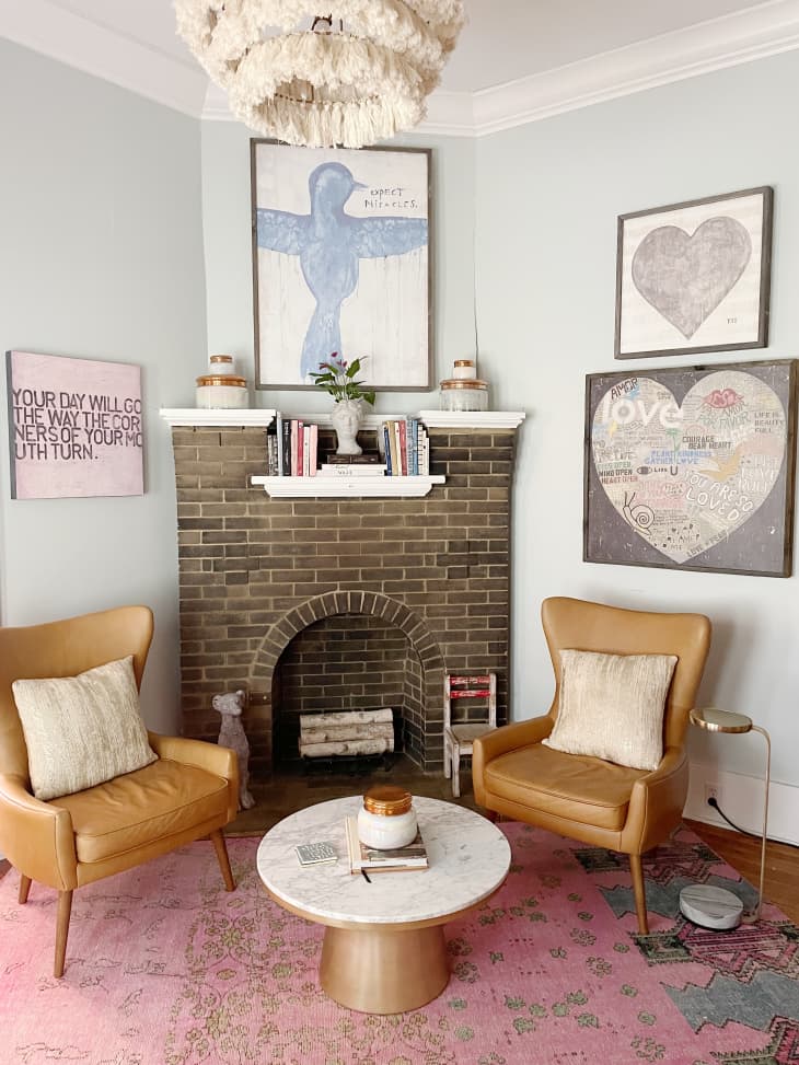 A brick fireplace with two brown chairs next to it