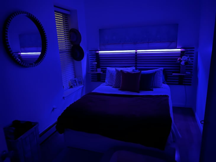 A bedroom at night with a blue light on