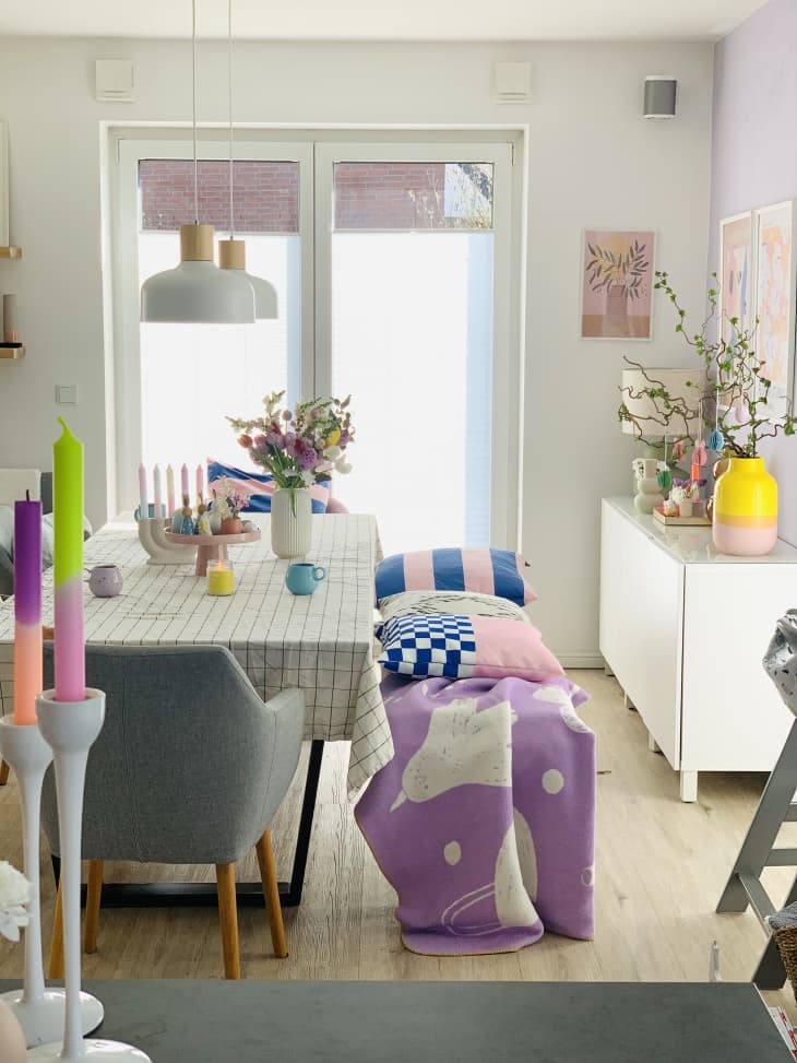bench, table cloth, airy, purple throw, pink and purple candle sticks, yellow vase, wood floors