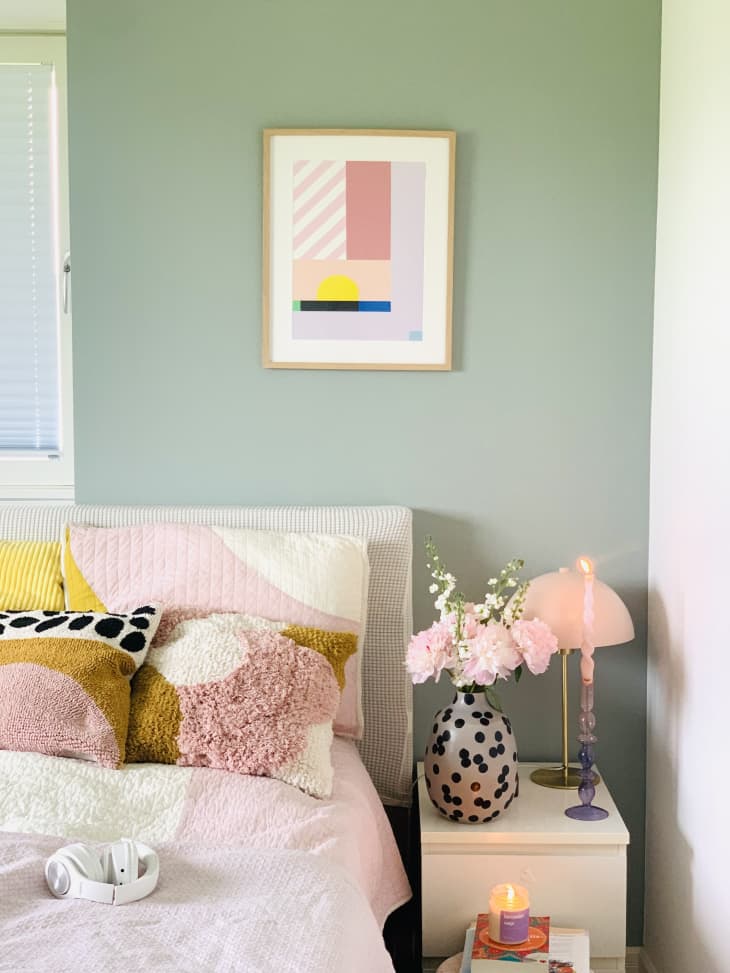 sage green wall, bedroom, pink sheets, pok-a dots, airy, plants, white nightstand, yellow and pink accents