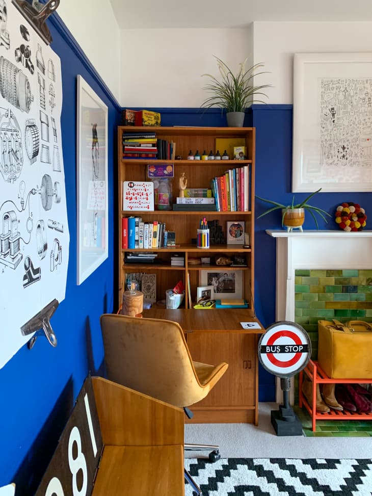 desk, book shelf, yellow fabric desk chair, natural wood, white and black patterned rug, bus stop sign, green tile, shoe shelf, plants, black and white art