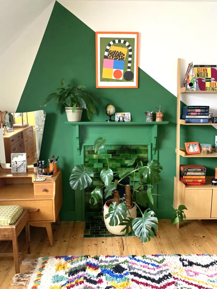 green color block mural, zig zag multi color rug, book shelf, books, plants, natural wood vanity, colorful art, floating shelf