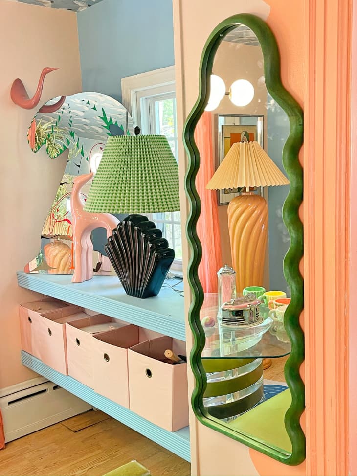 green pleated lamp shade, vintage green shell lamp base, wavy green mirror, buffet station, floating shelves, peach storage bins, peach curvy animal sculptures